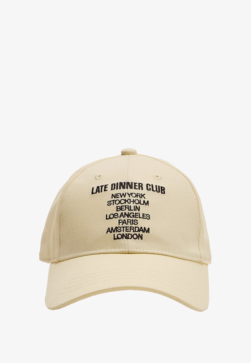 Beige Baseball-Cap mit gebogenem Schirm, versehen mit schwarzem gesticktem Text: "LATE DINNER CLUB" und Städtenamen in vertikaler Ausrichtung.