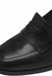 Moitié de cuir noir avec une finition lisse, comportant une large sangle horizontale et une couture détaillée le long de la couture. Design à semelle plate.