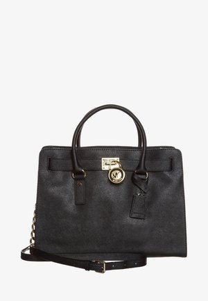 Zwarte leren Michael Kors handtas met dubbele handvatten, gouden logo-bedel en verstelbare schouderriem met gouden kettinkdetail.