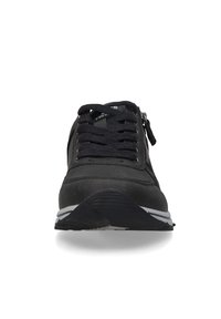 Schwarzer Sportschuh mit Obermaterial aus strukturiertem Leder, ausgestattet mit Schnürsenkeln, einem seitlichen Reißverschluss und einem geschwungenen weißen Akzent entlang der Sohle. Gummisohle.
