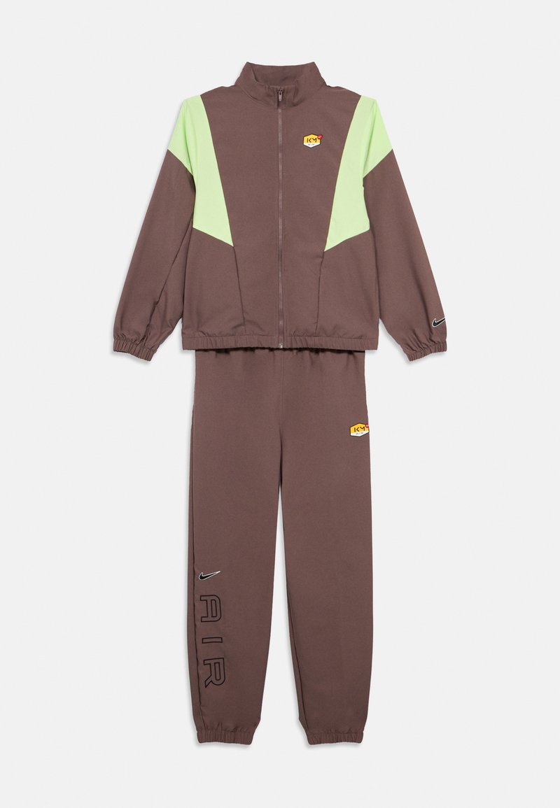 Καφέ φόρμα με ζακέτα με φερμουάρ, ανοιχτοπράσινα πάνελ και λογότυπο, και αντίστοιχο παντελόνι με τη λέξη «AIR» και ελαστικές μανσέτες.