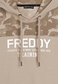 Felpa con cappuccio beige con motivo mimetico, dotata di cappuccio con coulisse e grande testo bianco "FREDDY ATHLETIC DEPARTMENT ESTABLISHED 1976 TRAINING."
