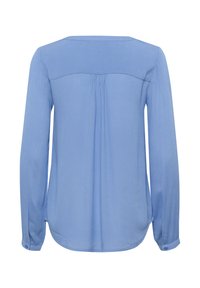 Blouse bleue clair à manches longues avec une texture lisse, ourlet arrondi, dos plissé et poignets boutonnés. Encolure simple et sans motifs visibles.