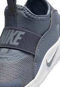 Nike sportbačiai su pilku tekstiliniu viršumi, tinklinėmis dalimis, elastinga juosta ir balta pado dalimi. Išskirtinis pilkas logotipas šone.