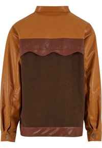 Braune Cordjacke mit braunen Kunstlederakzenten. Verfügt über ein gewelltes Design an den Schultern und über knöpfbare Ärmelabschlüsse.