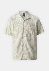 Kortarmig shirt van lichtbeige stof met bloemenpatronen, knoopsluiting aan de voorkant, kraag en een borstzakje aan de linkerkant.