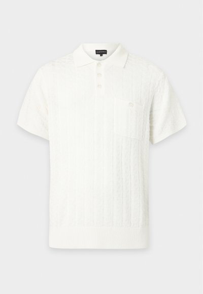 Polo blanc à manches courtes avec motif en maille texturée, patte de boutonnage à trois boutons, col et poche poitrine boutonnée.