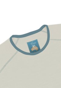 Hellbeiges Merinowoll-T-Shirt mit blauem Kragen. Verfügt über Flachnaht-Stichung und ein Etikett mit Markeninformationen, Größe und Pflegeanweisungen.