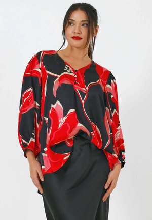 Black blouse with large red floral pattern, long sleeves, gathered cuffs, and a V-neck with three buttons. Paired with a black skirt.
