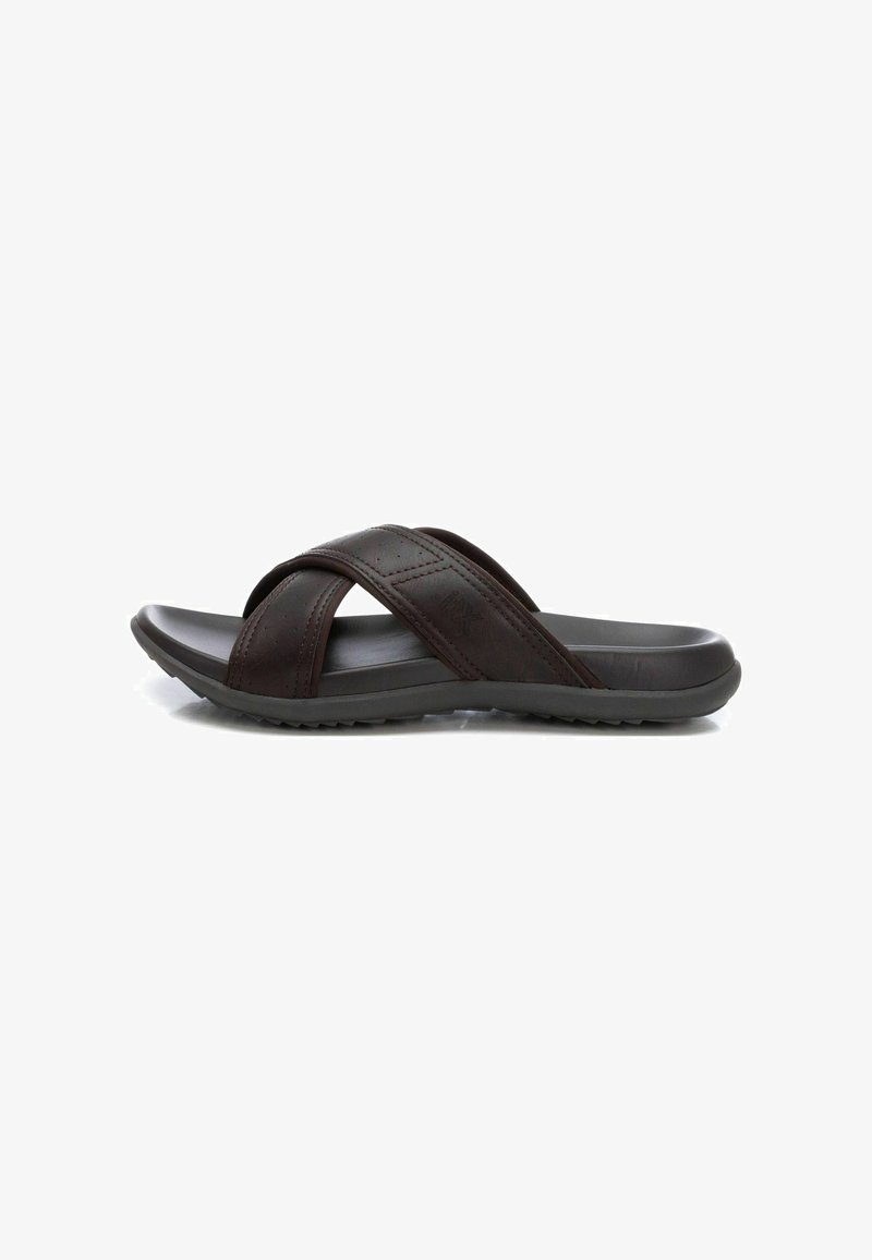 Sandalias de cuero marrón tipo slide con tiras entrecruzadas. Cuentan con una suela de goma blanda con una superficie texturizada para mayor agarre. Diseño ligero.