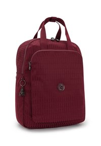 Bordeaux ryggsäck med texturerad tyg, fickor med dragkedja, dubbla handtag på toppen och en dekorativ charm. Har en rund logotyp på framsidan.
