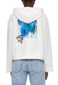 Weißer Hoodie mit einem verkürzten Design, der auf der Rückseite ein blaues abstraktes Grafikmotiv sowie handgeschriebene Texte darunter zeigt. Weiche Stofftextur.