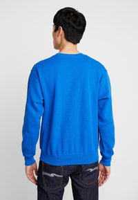 Felpa blu girocollo in misto cotone, con maniche lunghe, polsini e orlo ribattuti, texture liscia e vestibilità comoda.