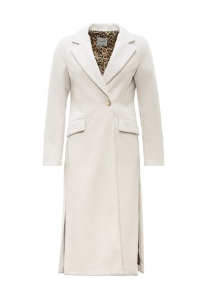 Lange op maat gemaakte crème kleurige jas met enkele knoop, inkeping revers, klepzakken en een zichtbaar leopardprintvoering aan de binnenkant.