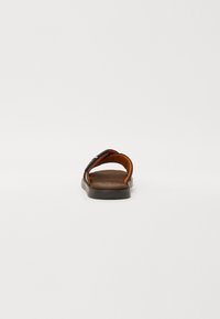 Brun sandaler med oransje stofffôr, med bred stroppedesign og flat såle. Glatt tekstur med en semsket fotbed.