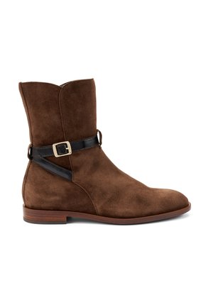 Bruine nubucklederen enkelboot met een ronde neus, voorzien van een zwarte leren band en een gouden gespaccent aan de zijkant. Vlakke houten zool.