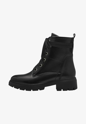 Botas de tobillo de cuero negro con suela de goma gruesa, parte frontal con cordones y ojales metálicos. Presenta una pestaña en la parte posterior y un upper texturizado.