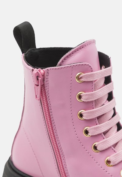 Botín de cuero rosa con forro negro, cremallera lateral, ojal dorado y cordones rosa claro. Presenta una suela resistente y una tira de sujeción.