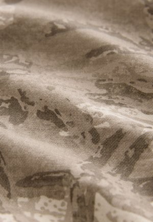 Tekstūrais audums bēša un gaiši brūnā toņos ar smalku rakstu. Mīksta, austā tekstūra ar viļņainiem virsmas elementiem.