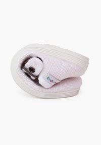 Zapato blanco plegable con parte superior texturizada, punta redonda y suela estrecha. Cuenta con una pequeña etiqueta colorida y un cierre de botón marrón.