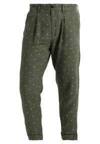 Olivově zelené kalhoty z lehké látky s volným střihem, řaseným předním dílem a vzorem bílých puntíků. Otočené manžety u kotníků.