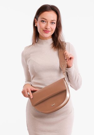 Tasche aus braunem Leder mit abgerundeter Klappe, metallischen Akzenten und verstellbarem Schultergurt. Glatte Textur, dezentes Logo und minimalistisches Design.