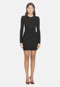 Abito nero lavorato a maglia con maniche lunghe, caratterizzato da decorazioni a pois dorati e una vita aderente, lungo fino al ginocchio con un motivo testurizzato.