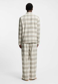 Gepunktetes Lounge-Set in Beige- und Hellblautönen. Weicher Stoff mit lockerem Schnitt, bestehend aus einer Jacke mit Kragen und weit geschnittenen Hosen.