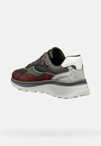 Sneaker da uomo con una combinazione di materiali grigio scuro, bordeaux e verde oliva. Suola bianca spessa con scanalature testurizzate e logo sul tallone.