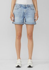 Lichtblauwe denimshorts met opgerolde manchetten, vijf-pocket ontwerp en een knoopsluiting. Draagbaar met witte sneakers.