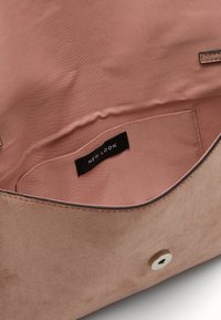 Miękka różowa torebka z zamszu, z materiałową podszewką i wewnętrzną kieszenią z oznaczeniem "NEW LOOK", z okrągłym metalowym zapięciem na magnes.