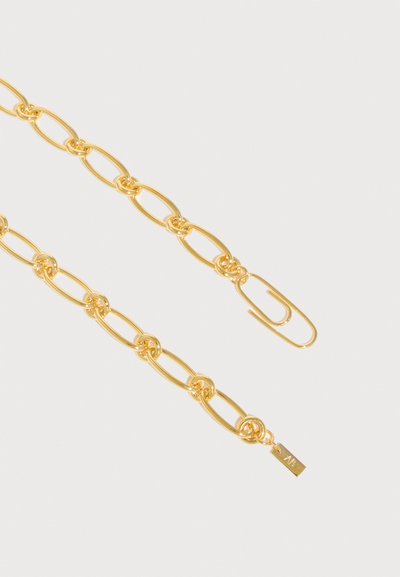 Κολιέ με αλυσίδα από χρυσό με επιμηκυμένους οβάλ κρίκους, κούμπωμα σε σχήμα συνδετήρα χαρτιού και μια μικρή ορθογώνια ταυτότητα χαραγμένη με το "AF" σε λευκό φόντο.