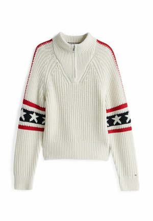 Jersey de punto en color crema, que cuenta con un cuello de media cremallera. Patrones de rayas rojas y negras en las mangas con detalles de estrellas blancas. Textura acanalada en toda la prenda.