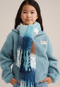 Svetlo modra flis jakna z teksturiranim zaključkom, v kombinaciji z pisanimi šalnimi rese v odtenkih modre, rjave in smetane.