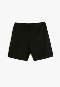 Shorts noirs en tissu doux, avec une taille élastique et un design simple, sans ornements, avec une coupe droite.
