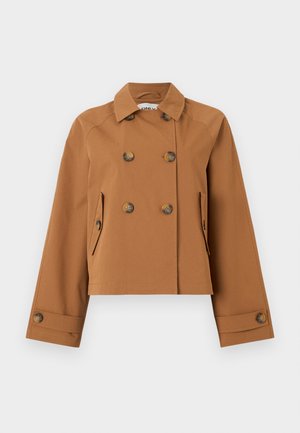 Veste marron courte à double boutonnage avec large col, deux poches à rabat boutonnées et détails de boutons sur les poignets, présentée sur fond blanc.