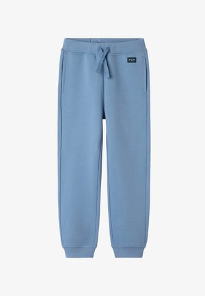 Blauwe kinderbroek met elastische tailleband, trekkoord, zijzakken, geribbelde manchetten en een klein "P.O.P" etiket aan de voorkant.