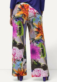 Brede broek met een kleurrijke bloemenprint in tinten roze, oranje en groen, gemaakt van lichtgewicht stof met een zachte textuur.