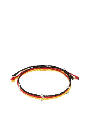 Trois bracelets en corde tressée en noir, rouge et jaune avec de petites perles en argent sur un fond blanc.