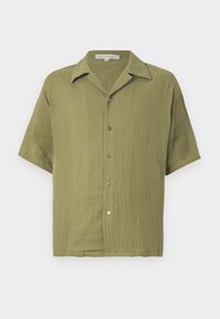 Camisa de mangas cortas verde oliva con un tejido texturizado, cierre de botones y cuello con muesca. Presenta un corte relajado y un sutil patrón de tejido.