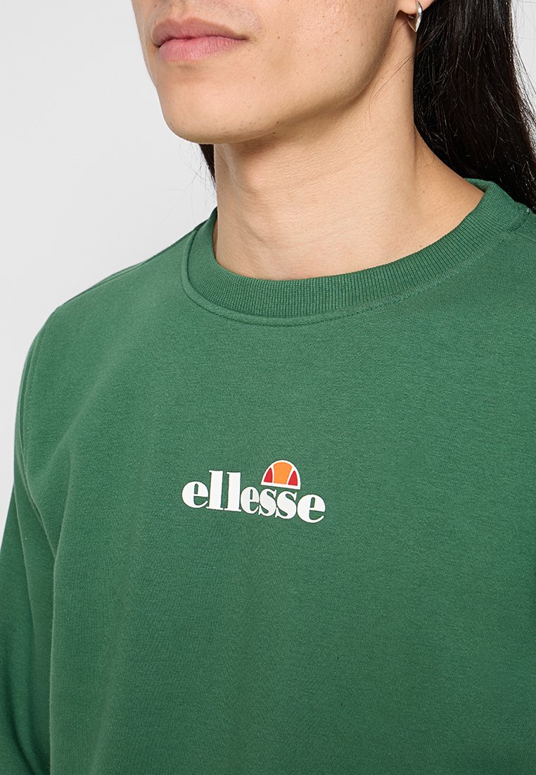 Sudadera verde con cuello redondo, hecha de un tejido suave. Presenta un logo blanco con un acento rojo y naranja en el pecho.