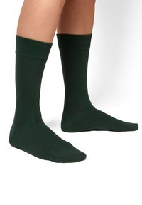 Grüne Baumwollsocken mit einem gerippten Bündchen, mittellanger L�änge, glatter Textur und einem engen Sitz um den Fuß und das Bein. Keine sichtbaren Muster.