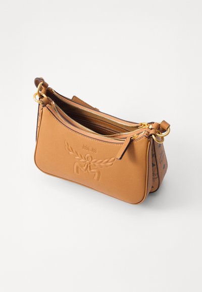 Borsa in pelle marrone chiaro MCM con logo impresso, due scomparti con zip e attacchi per cinghie in metallo dorato.