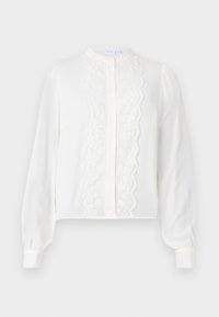 Blusa bianca a maniche lunghe con colletto rotondo, presenta un pannello centrale in pizzo e chiusura con bottoni, con maniche arricciate ai polsi.