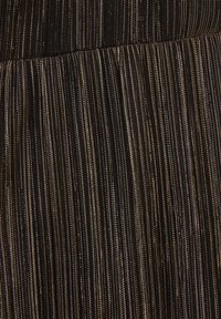 Svart tyg med vertikala guld- och silverränder, med en strukturerad yta. Materialet är slätt och något reflekterande.