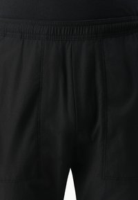 Black athletic pants featuring an elastic waistband, side pockets, and a lightweight, textured fabric with subtle vertical stripes.