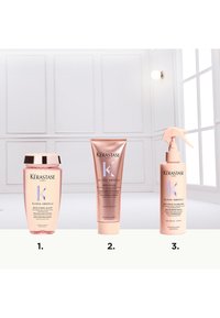 Tre prodotti per la cura dei capelli Kérastase Gloss Absolu: una bottiglia trasparente di shampoo, un tubo rosa e una bottiglia spray, tutti con design eleganti e colori pastello.