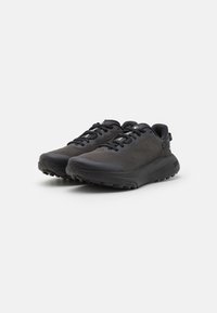 Baskets de sport noires avec une tige en mesh texturé, un col rembourré et une semelle en caoutchouc. Comprend des lacets, des accents de logo et un design de semelle incurvée.