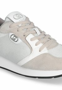 Baskets gris clair avec des matériaux en maille et en daim, accents blancs, design à lacets et logo rond sur le côté. Détails texturés visibles.