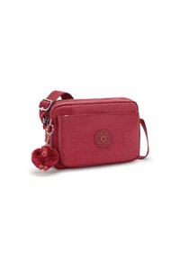 Borsa a tracolla rossa in nylon con finitura testurizzata, dotata di un patch con logo frontale e un charm a forma di scimmia pelosa attaccato allo zip.